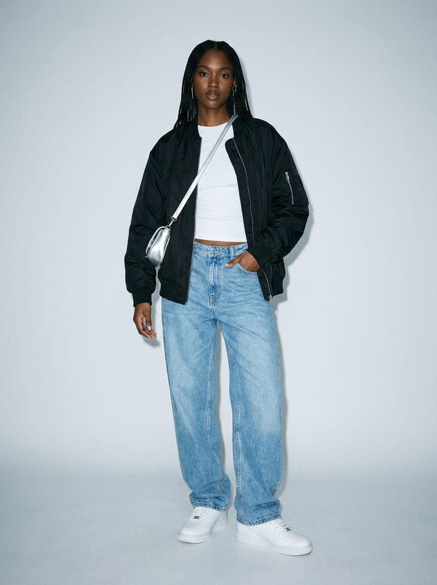 This week's featured outfit: black bomber jacket, white tee, baggy light-wash jeans and white sneakers, full body